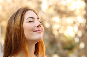 Beautiful woman doing breath exercises with an autumn background
