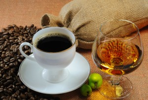 Cup of coffee, cognac glass and bags of coffee beans