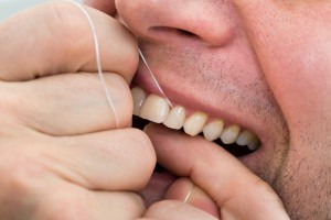 Close-up Of A Man Flossing His Teeth