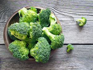 Raw broccoli in a bowl on rustic background