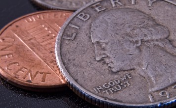 quarter and a penny on a black background