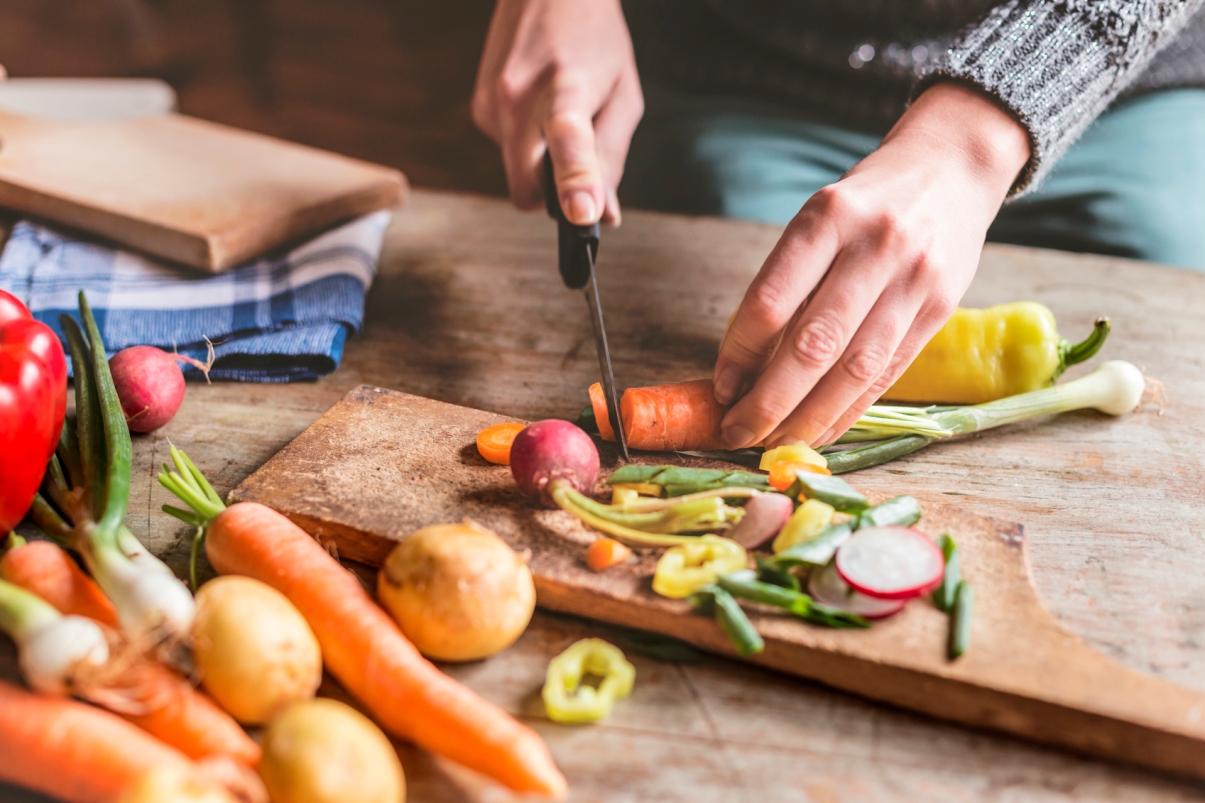 hands holding a knife; chopping vegetables