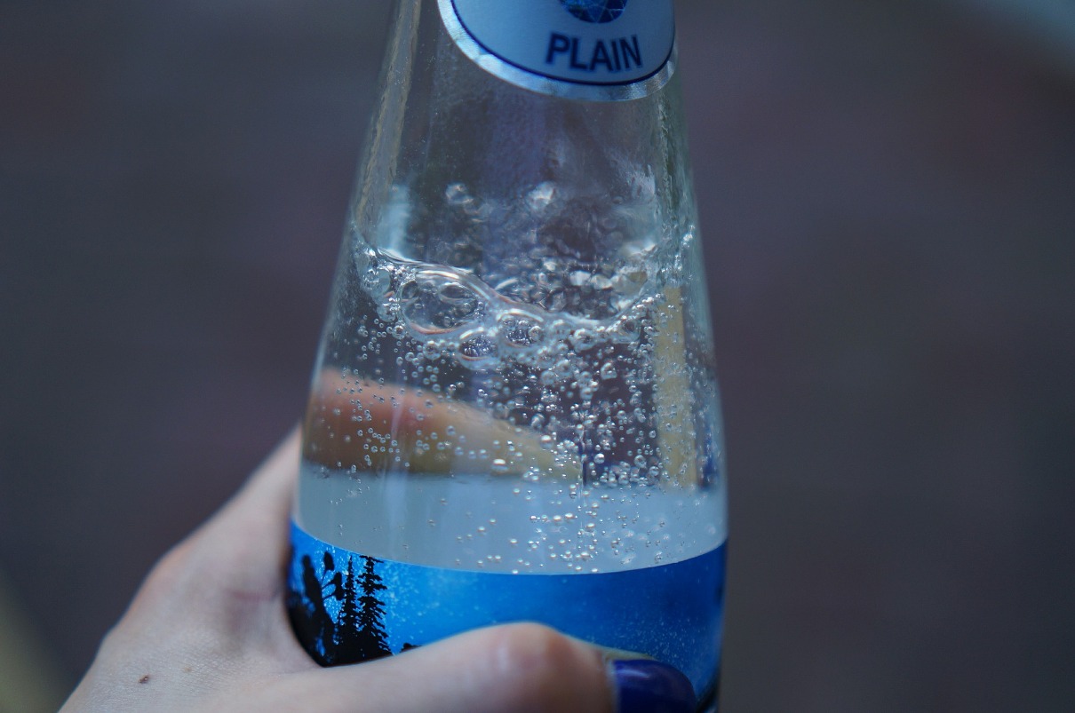 hand holding a bottle of sparkling water
