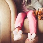 puppy snuggling with his girl on a couch