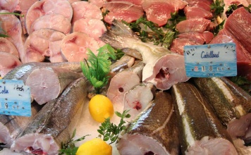 assorted cuts of fish displayed at a fish market