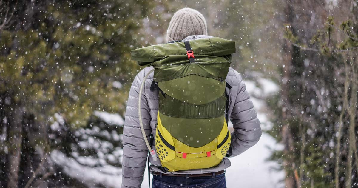 man with hiking gear walking in snow