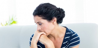 anxious looking woman leaning on her folded hands