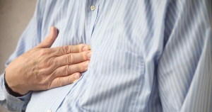 man holding his hand on his chest with chest pain