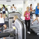 42249094 – elevated view of busy gym with people exercising on machines