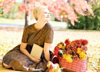 Three Strategies for Mindful Eating Happy woman sitting on a blanket in the park with baskets of apples and fall flowers