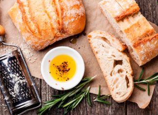 Did You Know… Your Olive Oil is Probably Fake? Sliced bread Ciabatta and extra virgin Olive oil on wooden background