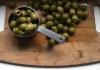 pitted green olives on a wood board