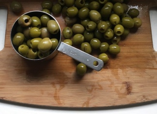 pitted green olives on a wood board