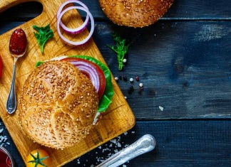 The Next Generation of Plant-Based Scientists cutting board with a burger and a hearty bun with onion, pepper, and ketchup on the side