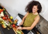 happy woman cutting produce on a cutting board
