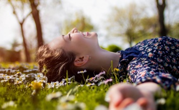 This Simple Trick Rewires Your Brain for Happiness woman laying in the grass