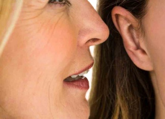 A Woman’s Secret Helper? The safe, powerful herb proven for PMS, tummy troubles, and now, post-menopausal symptoms Woman whispering into another woman's ear